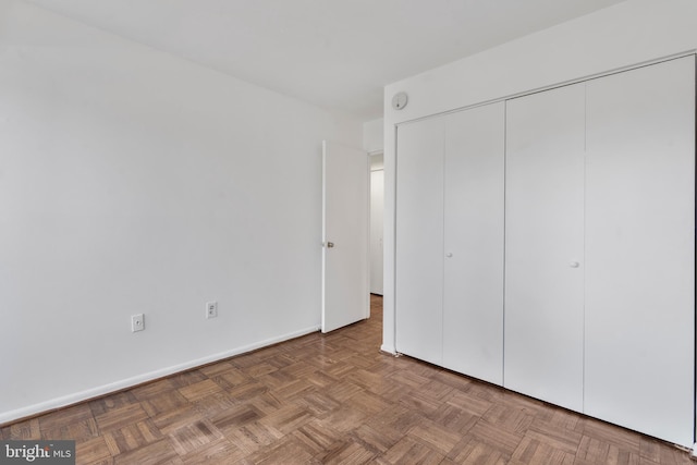 unfurnished bedroom with a closet and baseboards