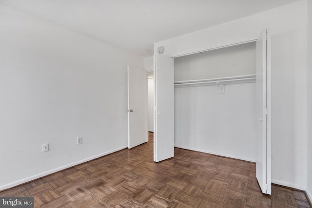 unfurnished bedroom featuring a closet and baseboards