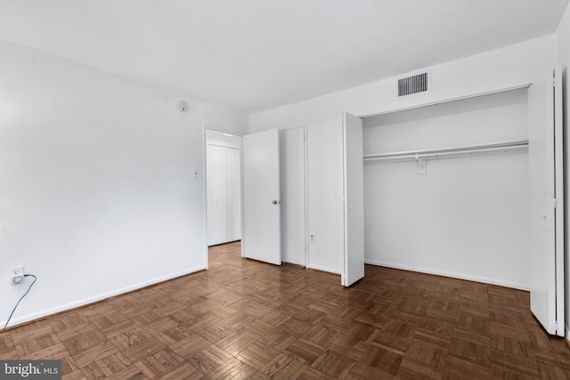 unfurnished bedroom featuring a closet, visible vents, and baseboards