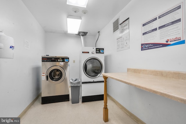 community laundry room featuring separate washer and dryer and baseboards