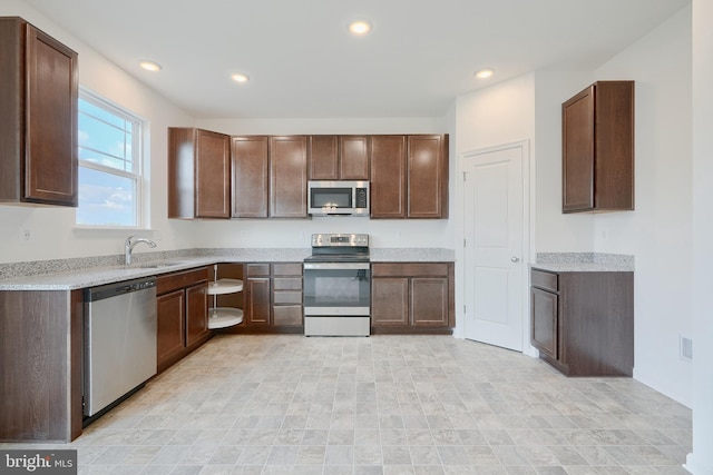 kitchen with appliances with stainless steel finishes, light countertops, and dark brown cabinetry