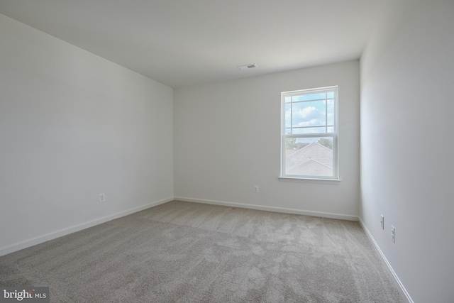 unfurnished room featuring light carpet, visible vents, and baseboards