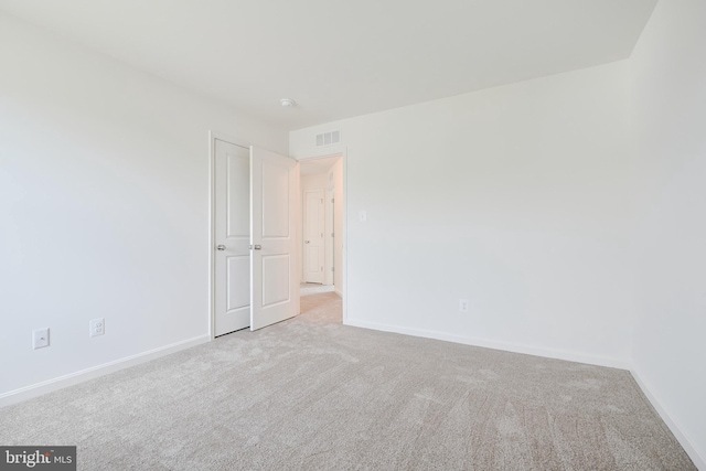 empty room with light carpet, baseboards, and visible vents