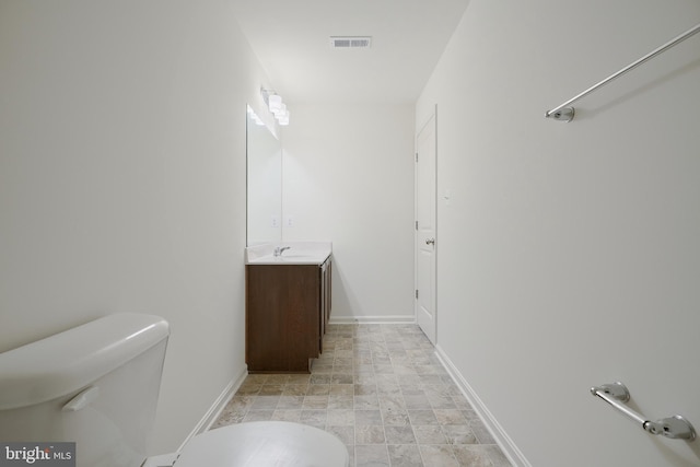 bathroom with toilet, baseboards, visible vents, and vanity