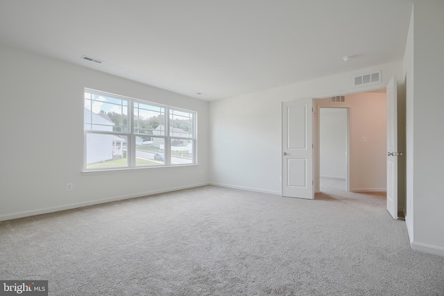 unfurnished room with light carpet, baseboards, and visible vents