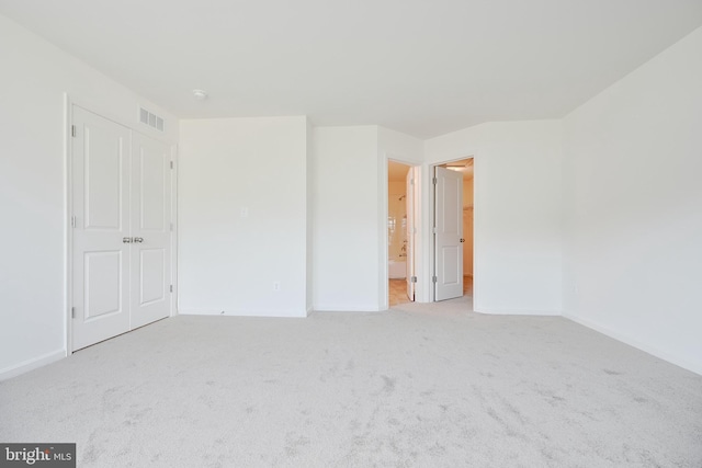 unfurnished bedroom featuring a closet, visible vents, light carpet, and baseboards