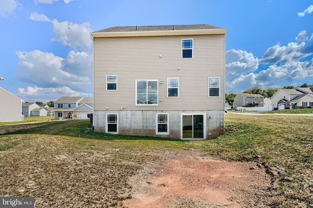 back of house with a residential view and a lawn