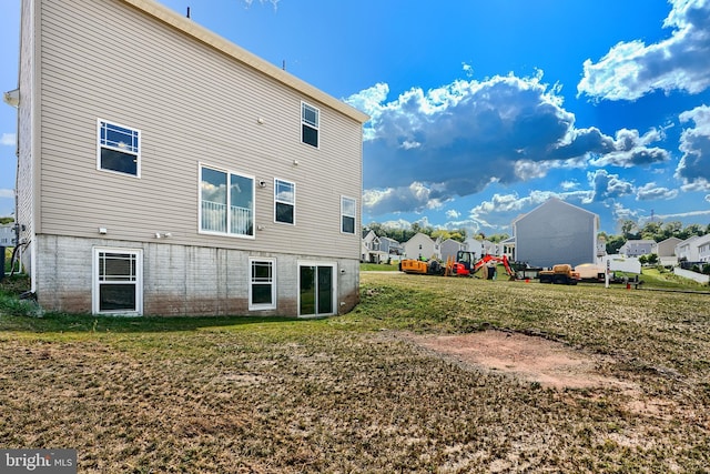 back of house featuring a residential view and a yard