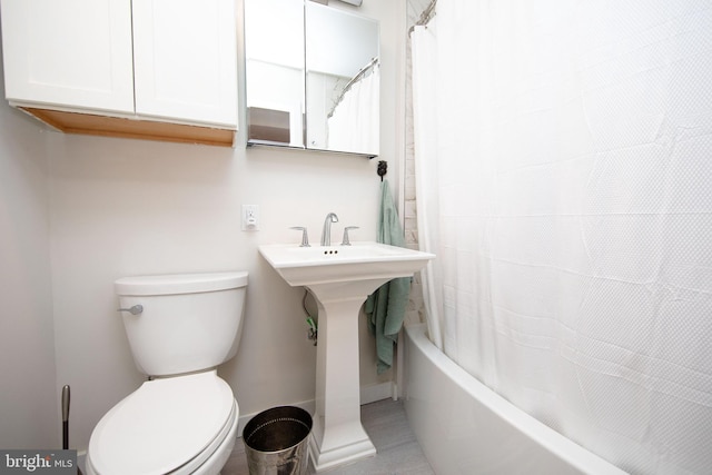 full bath featuring toilet, baseboards, and a sink