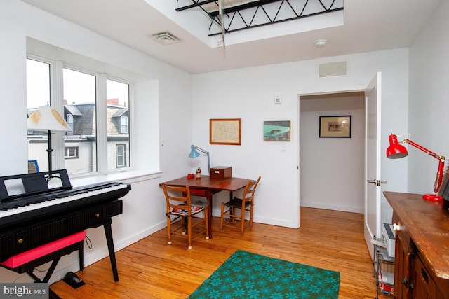 home office featuring light wood-type flooring, visible vents, and baseboards