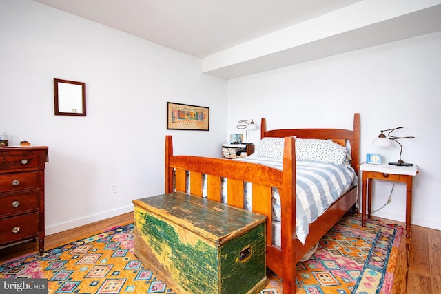 bedroom featuring wood finished floors and baseboards