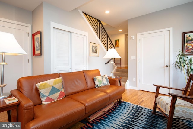 living room with recessed lighting, wood finished floors, and stairs