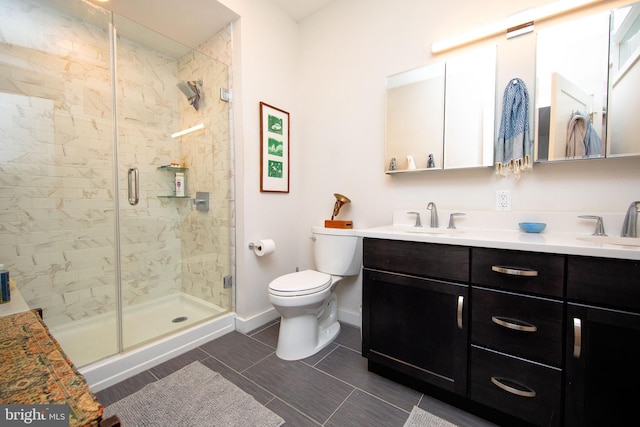 bathroom featuring double vanity, a stall shower, baseboards, toilet, and a sink