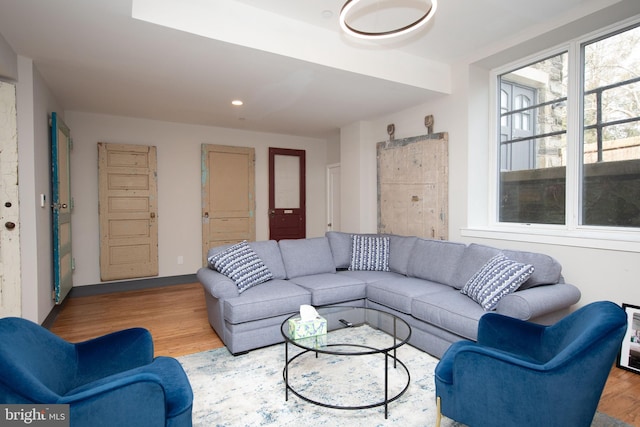 living area with baseboards, wood finished floors, and recessed lighting