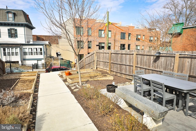 surrounding community featuring a fenced backyard, a vegetable garden, and outdoor dining area