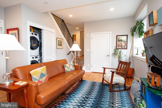 living room with stacked washing maching and dryer, stairs, wood finished floors, and recessed lighting