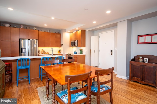 dining area featuring light wood-style floors, baseboards, and recessed lighting