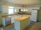 kitchen with a kitchen island, light countertops, freestanding refrigerator, and decorative light fixtures