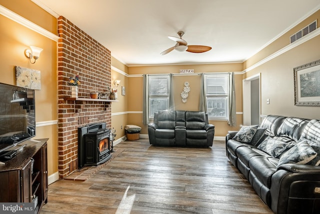 living room with visible vents, wood finished floors, a ceiling fan, and ornamental molding