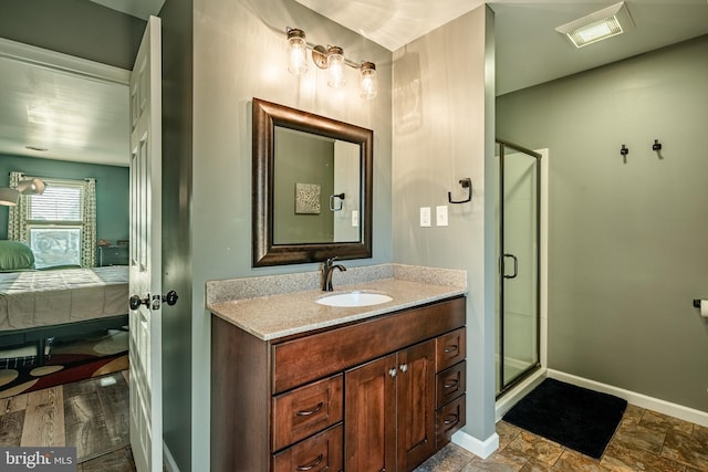 ensuite bathroom with vanity, visible vents, baseboards, a shower stall, and connected bathroom