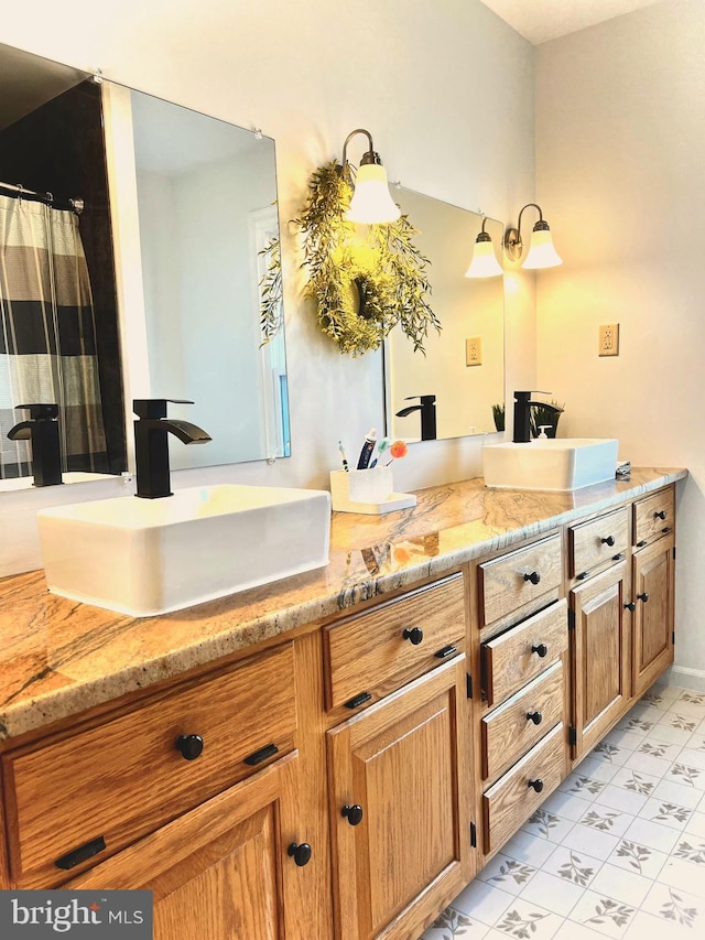 bathroom featuring double vanity, marble finish floor, and a sink