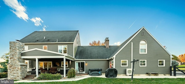 back of house featuring ac unit, a lawn, roof with shingles, a chimney, and a patio area