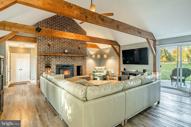 living room featuring baseboards, vaulted ceiling with beams, and hardwood / wood-style flooring