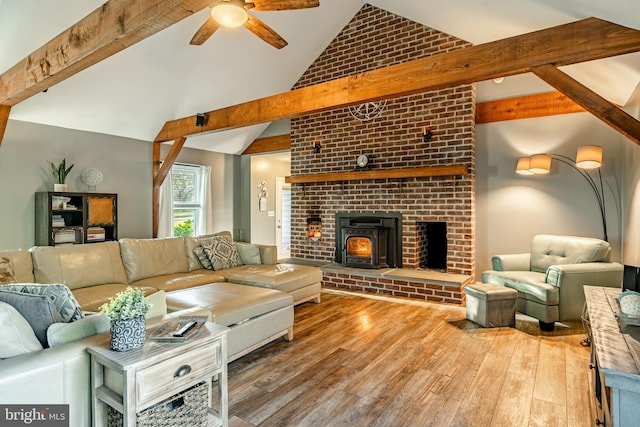 living area with ceiling fan, wood finished floors, and vaulted ceiling with beams