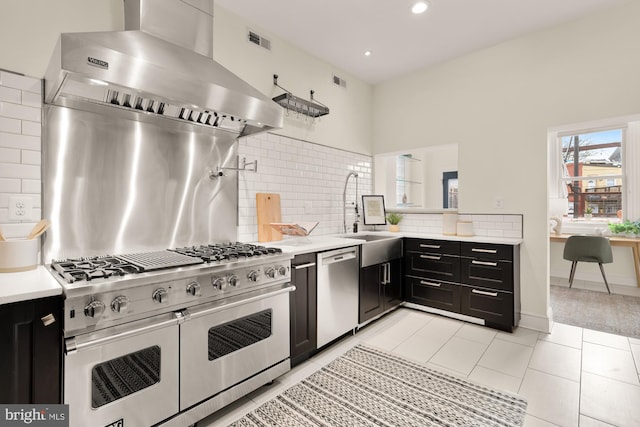 kitchen with visible vents, wall chimney exhaust hood, appliances with stainless steel finishes, dark cabinets, and light countertops