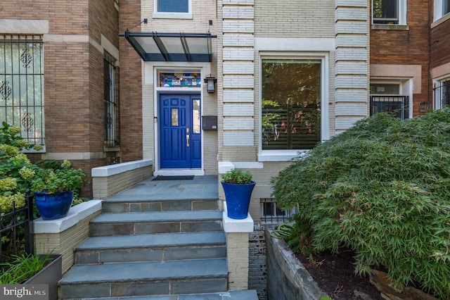 entrance to property featuring brick siding