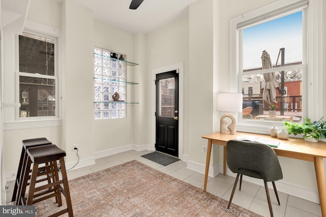 office area with ceiling fan, baseboards, and light tile patterned flooring