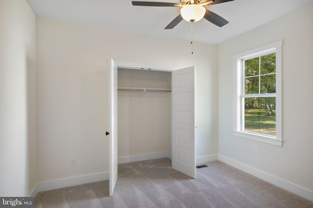 unfurnished bedroom with a closet, light colored carpet, visible vents, and baseboards