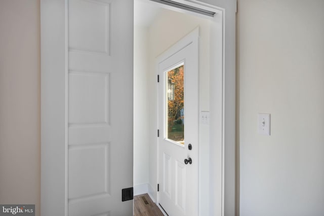 entryway with baseboards and wood finished floors