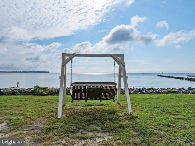 view of community with a water view and a lawn