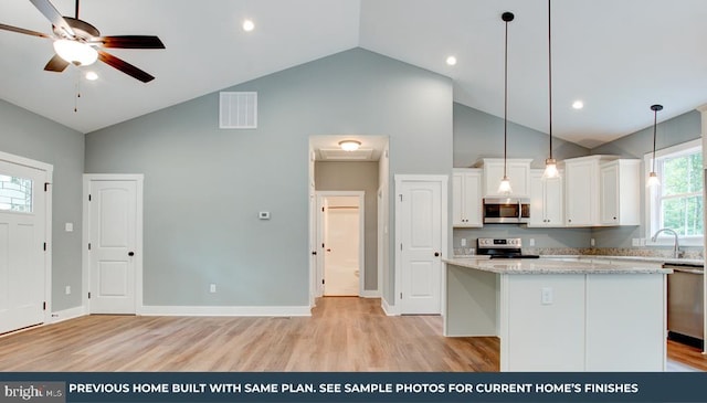 kitchen featuring visible vents, appliances with stainless steel finishes, white cabinetry, and a center island