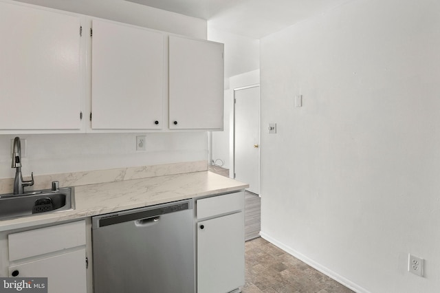 kitchen with dishwasher, light countertops, white cabinets, and a sink