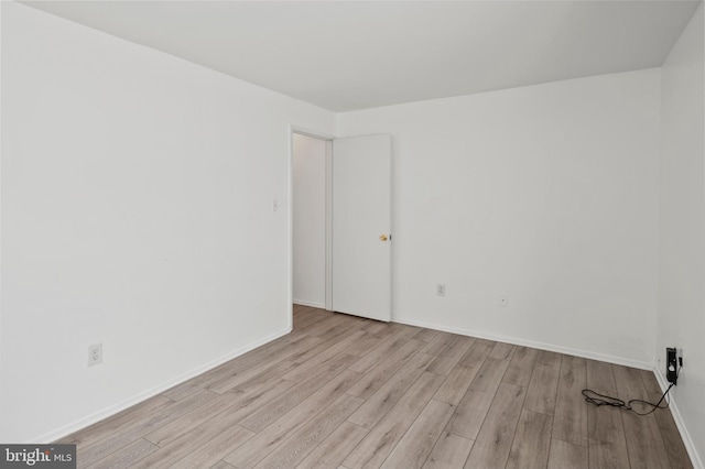 empty room with baseboards and wood finished floors