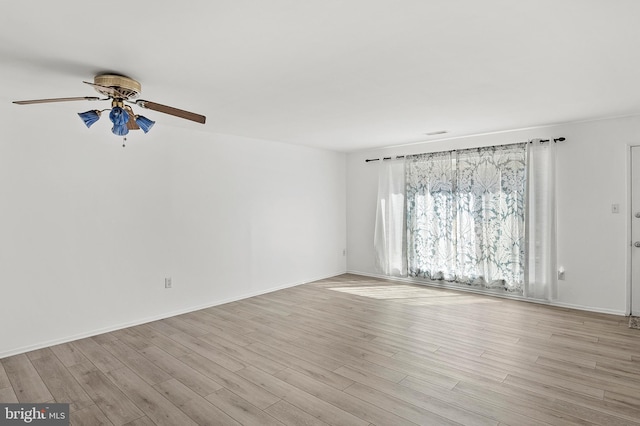 unfurnished room with baseboards, ceiling fan, and light wood finished floors