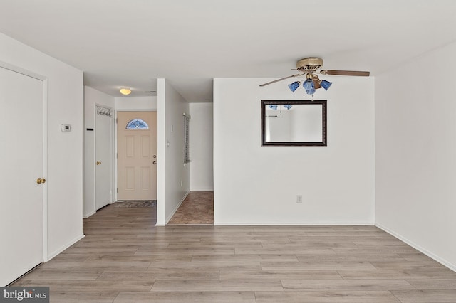 interior space with light wood-style floors, baseboards, and ceiling fan