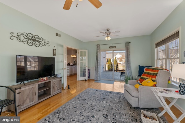 living room with french doors, wood finished floors, visible vents, and a ceiling fan