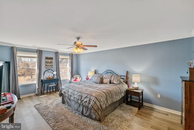 bedroom featuring light wood-type flooring, baseboards, and a ceiling fan