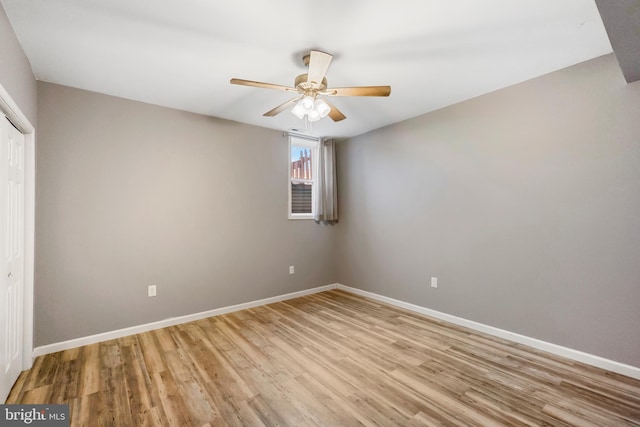 unfurnished bedroom featuring light wood finished floors, ceiling fan, baseboards, and a closet