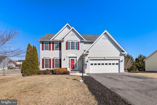 traditional-style home with an attached garage, a shingled roof, a front lawn, and aphalt driveway