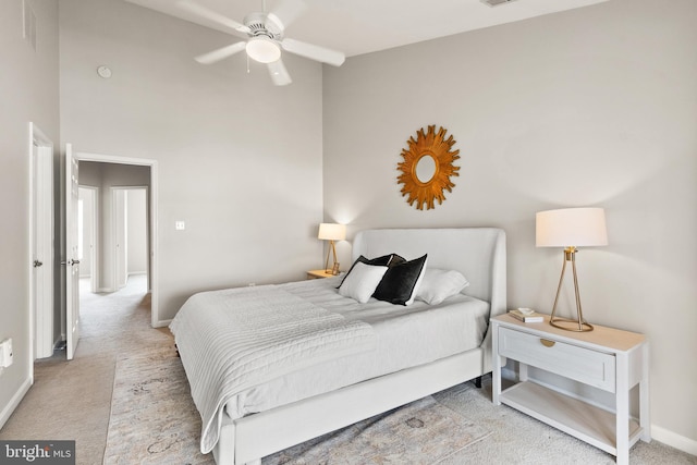 carpeted bedroom with a high ceiling, visible vents, and baseboards