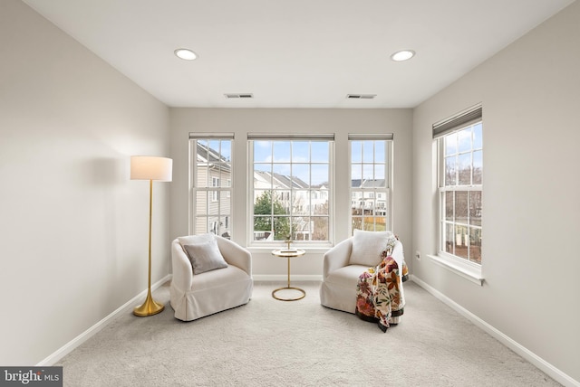 sitting room featuring carpet flooring, visible vents, and baseboards