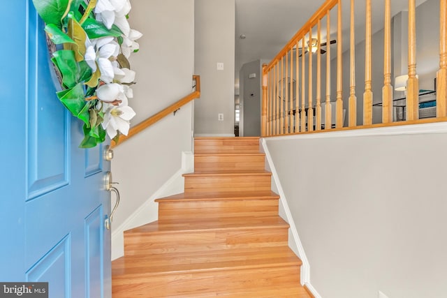 stairs featuring wood finished floors and baseboards