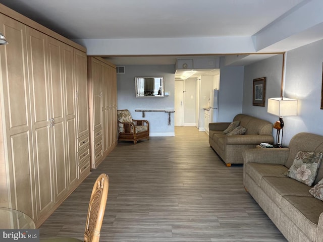 living room with visible vents, light wood-style flooring, and baseboards