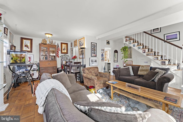 living area featuring arched walkways and stairway