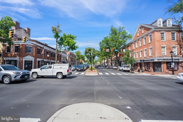 view of road with sidewalks, street lighting, and curbs