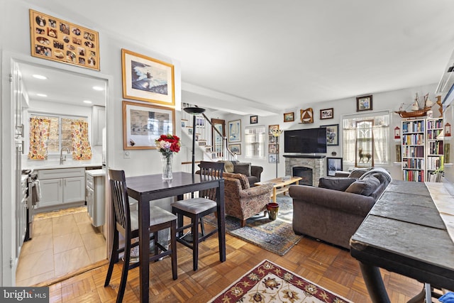 dining room featuring stairs, a fireplace, and recessed lighting